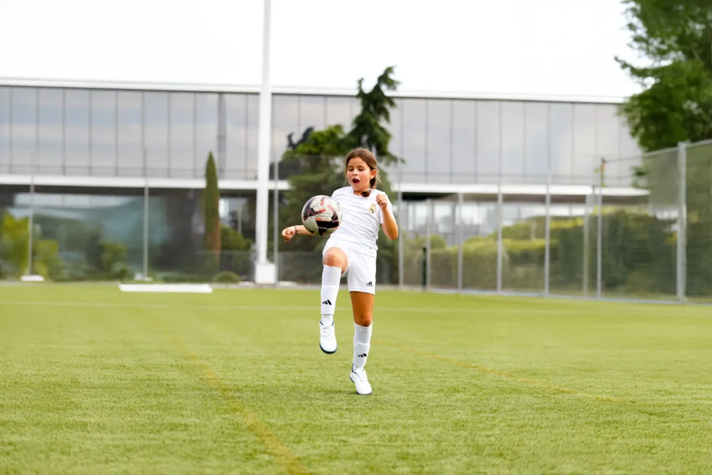 Niña con equipación del Real Madrid entrenando tácticas en fútbol en el Campus Experience.
