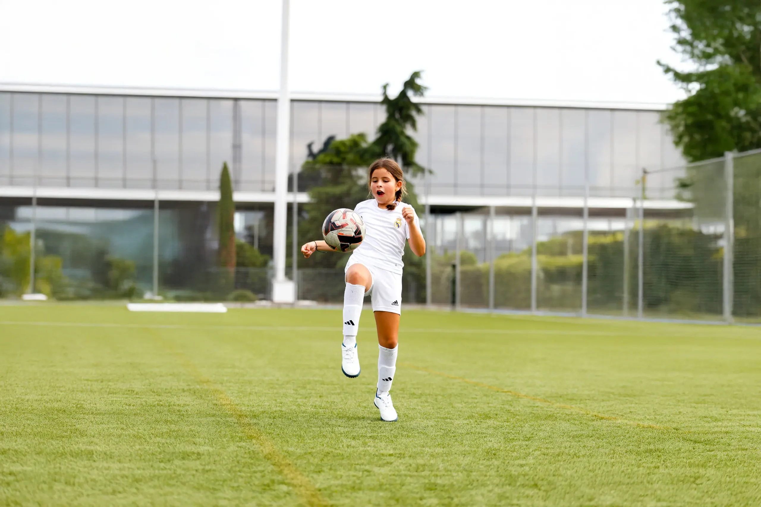 Niña con equipación del Real Madrid entrenando tácticas en fútbol en el Campus Experience.