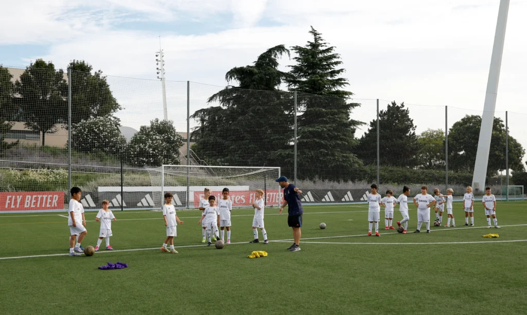 Niños y entenador en el campus de fútbol de verano de Real Madrid Foundation