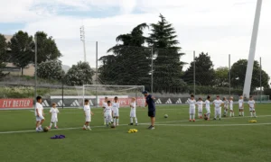 Niños y entenador en el campus de fútbol de verano de Real Madrid Foundation